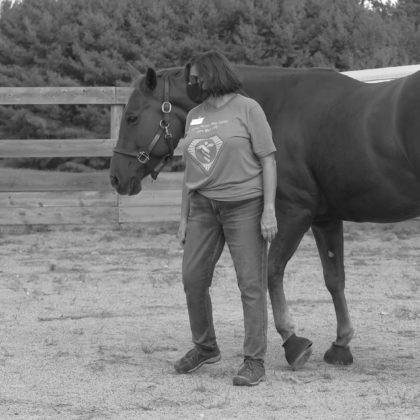 Health care worker interacting with a horse. 